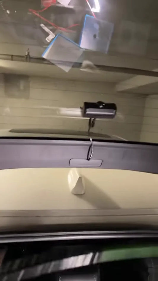 Rear camera mounted on Honda Civic hatchback glass with cable hanging into cargo area