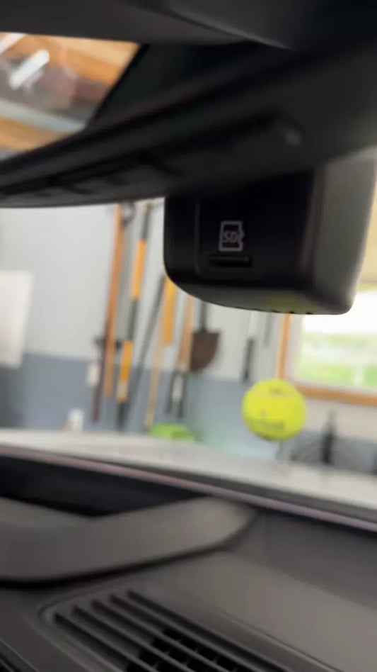 Factory windshield-mounted camera housing with an SD card symbol and card slot