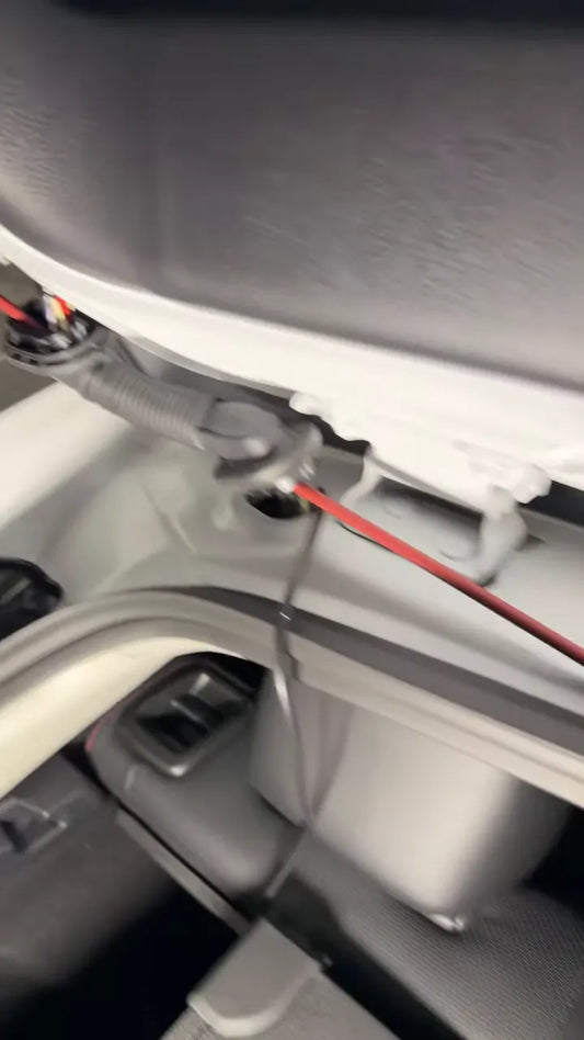Wire fish tool attached to rear dash camera cable near hatch wiring boot